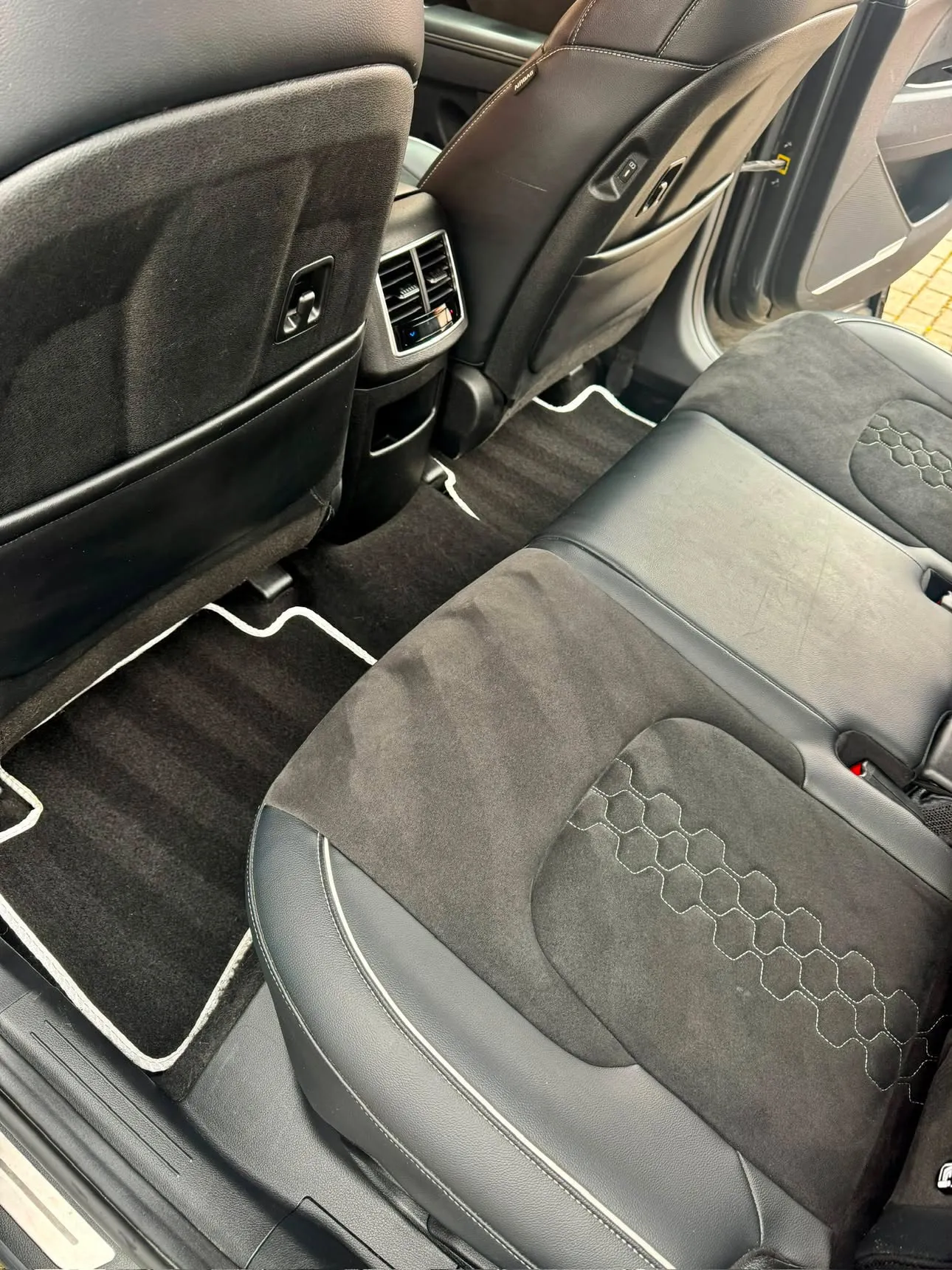 The same footwell and rear seat cleaned, the carpet vacuumed into stripes and the mat back to black.