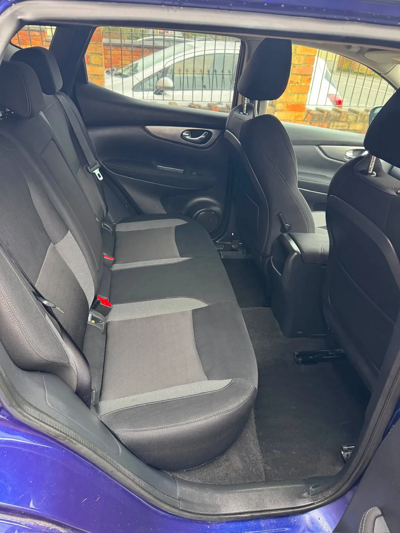 The same rear bench cleaned back to bare black fabric, carpets vacuumed, no trace of the mould.